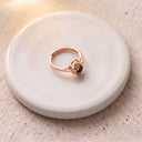Eternal Flower Projection Ring in rose gold on a round dish