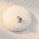 Minimalist Projection Charm in silver on a shell