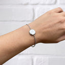 Woman wearing the silver Always With You Locket Bracelet with the round locket closed on her wrist
