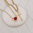 Heart & Sword Couple's Necklace in gold on a shell