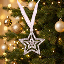 Shiny Star Projection Christmas Ornament hanging on a Christmas tree