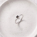 Eternal Flower Projection Ring in silver on a ceramic plate