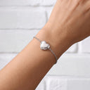 Woman wearing the silver Forever In My Heart Locket Bracelet with the heart locket closed on her wrist

