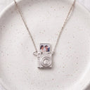 Camera Custom Photo Locket in silver, on a ceramic plate