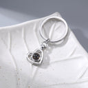 Heart Projection Keychain in silver on a leaf dish