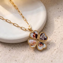 All My Hearts Locket Necklace unfolded into four hearts, each holding a custom photo, on a speckled ceramic plate
