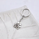 Paw Print Memorial Projection Keychain in silver on a leaf dish