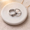 Minimalist Couple Projection Ring in silver on a round dish