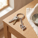 I Love You Projection Keychain in silver with keys on a table