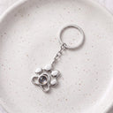 Paw Print Memorial Projection Keychain in silver on a ceramic plate