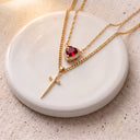 Heart & Sword Couple's Necklace in gold displayed on a round dish