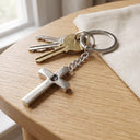 Cross Projection Keychain in silver with keys on a table