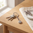 Minimalist Flower Projection Keychain with keys on a table