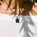 Square Pendant Projection Necklace in black, worn by a model