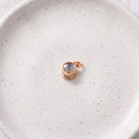 Minimalist Projection Charm in rose gold on a ceramic plate