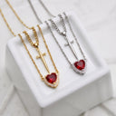 Heart & Sword Couple's Necklace in silver and gold on a marble cube