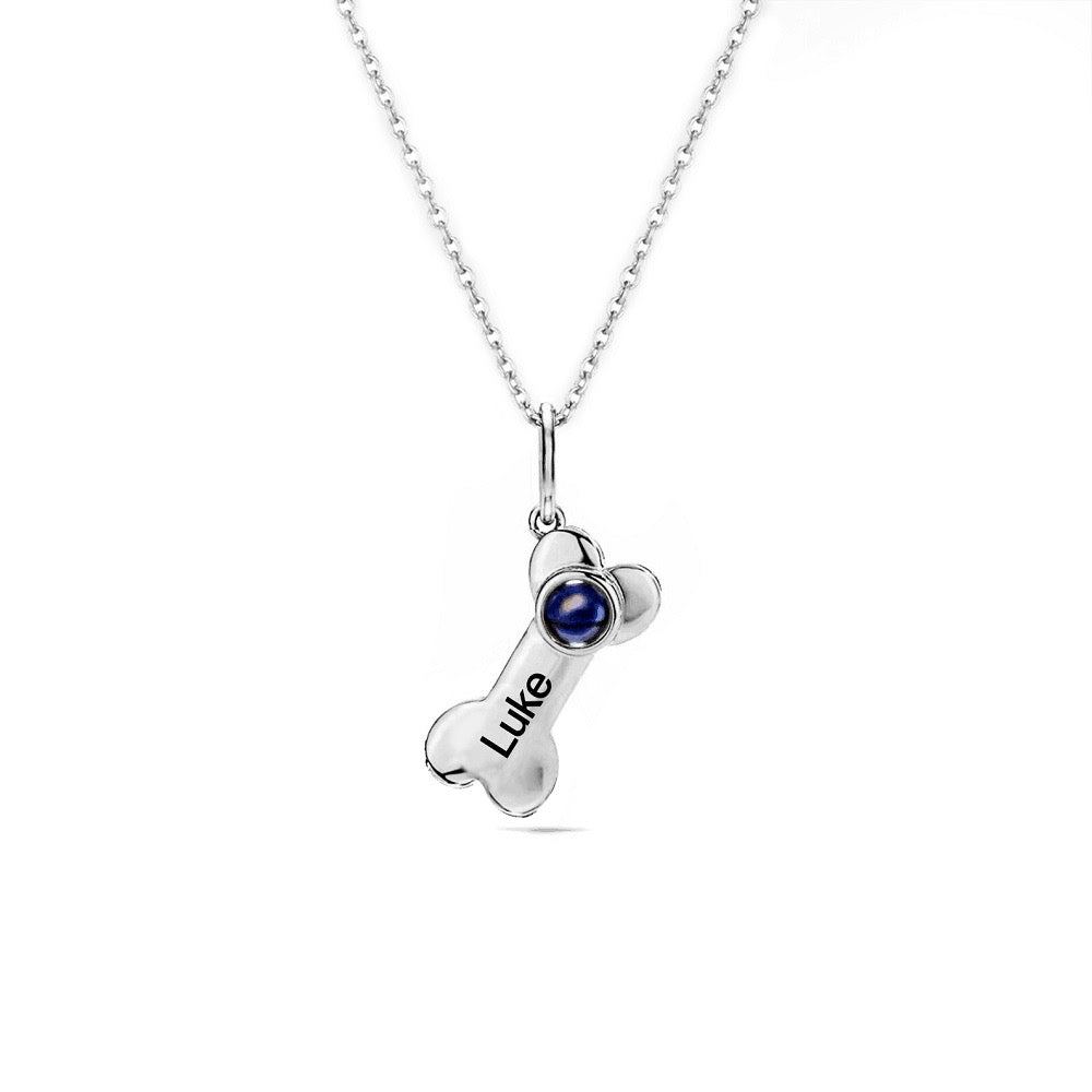 "cherished memories necklace: a heartfelt accessory featuring a dog bone charm and a sentimental projection."