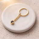 Minimalist Projection Keychain in gold on a round dish