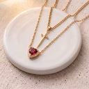 Heart & Sword Couple's Necklace in gold on a round dish