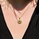 Minimalist Sunflower Projection Necklace in gold, worn by a model