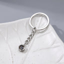 Minimalist Projection Keychain in silver on a leaf dish