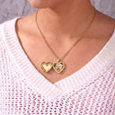 Woman wearing the gold Sparkling Heart Locket Necklace with the heart locket closed, over a knitted jumper

